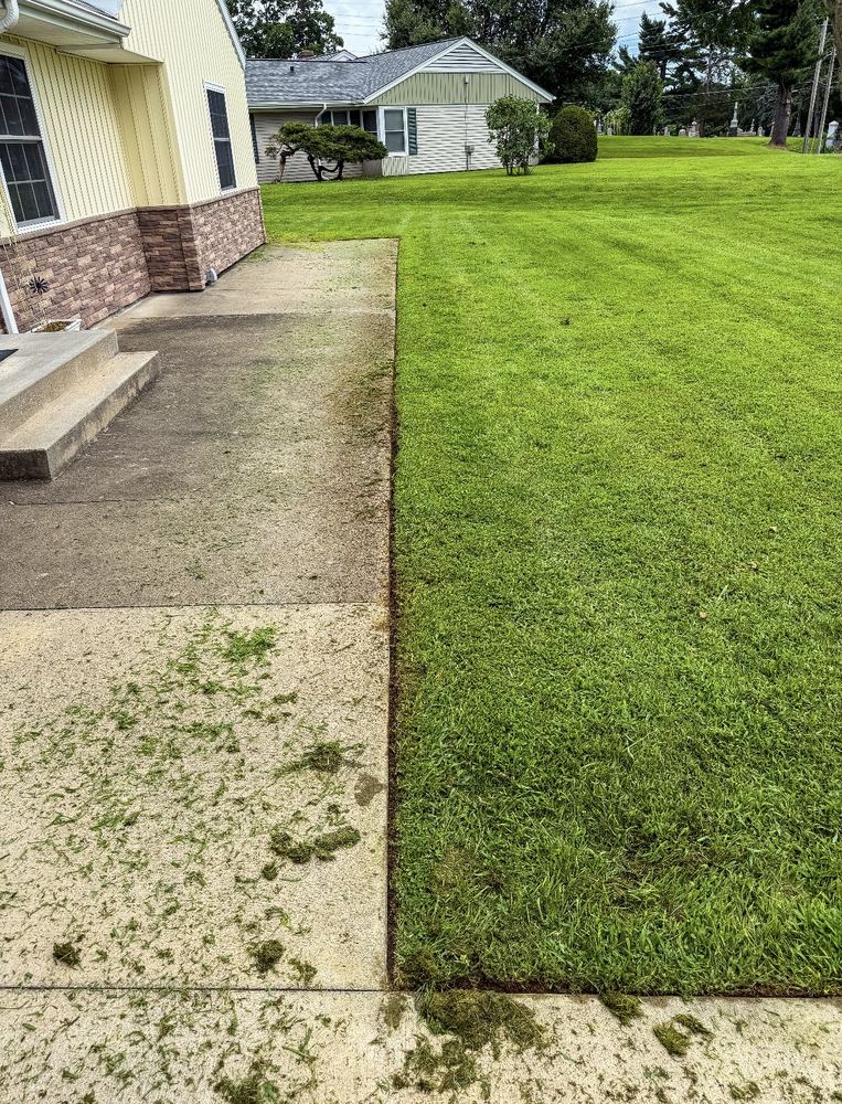 Freshly mowed lawn edge along a home's patio and sidewalk