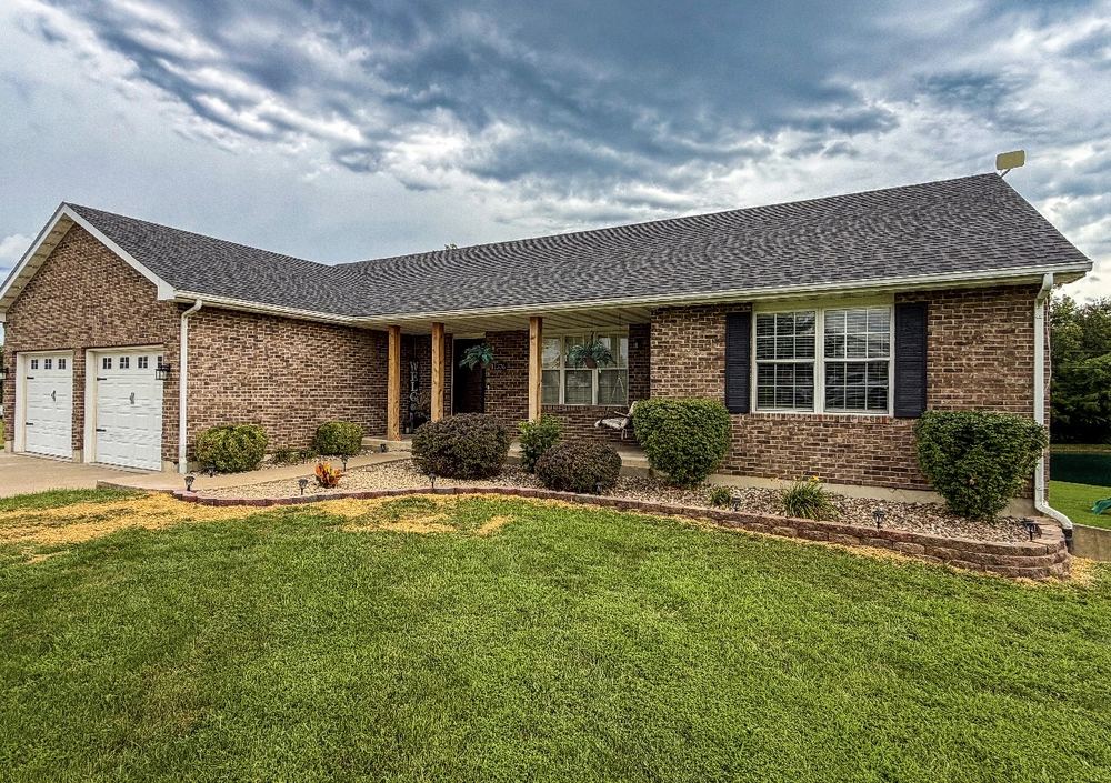 Brick home with manicured front lawn and landscape bed